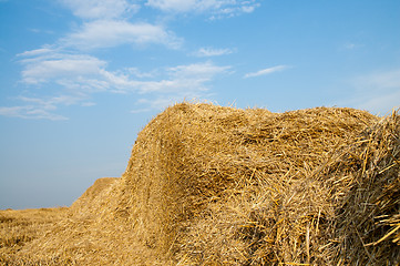 Image showing stack of straw on a background blue sky with clouds