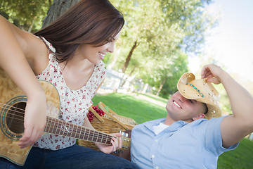 Image showing Mixed Race Couple with Guitar and Cowboy Hat in Park