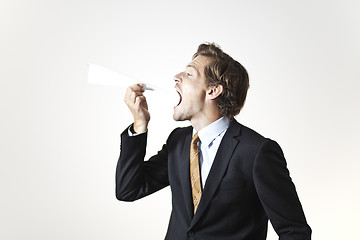 Image showing Businessman eating paper airplane