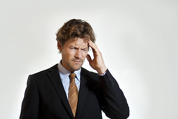 Image showing Aching businessman grabbing his head in pain