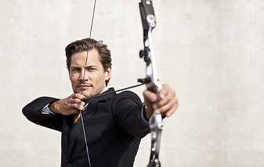 Image showing Businessman aiming bow and arrow