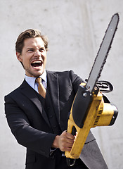 Image showing Angry businessman with blurred chainsaw