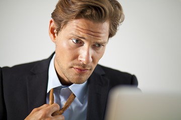 Image showing Stressed businessman working on laptop