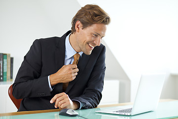 Image showing Smiling businessman sitting at desk