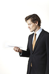 Image showing Skeptical businessman looking at paper airplane