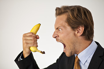 Image showing Angry businessman shouting at banana