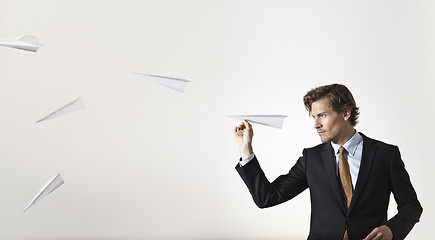 Image showing Businessman throwing paper airplanes at target