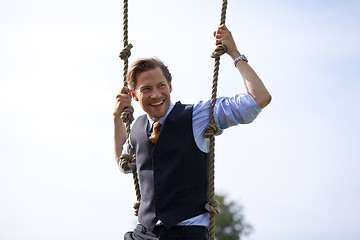 Image showing Smiling businessman swinging in ropes