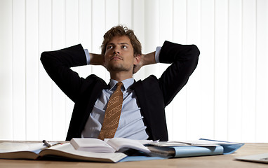 Image showing Wondering businessman leaning back in his chair