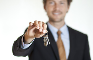 Image showing Smiling businessman handing keys 