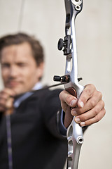 Image showing Determined businessman aiming bow