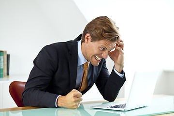 Image showing Frustrated Businessman Sitting At Desk In Office Using Laptop