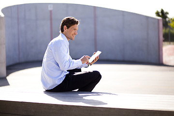 Image showing Relaxed businessman holding tablet