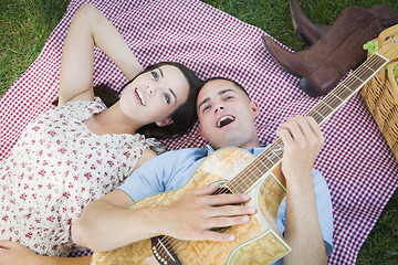 Image showing Mixed Race Couple at the Park Playing Guitar and Singing