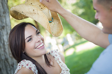 Image showing Mixed Race Romantic Couple with Cowboy Hat Flirting in Park