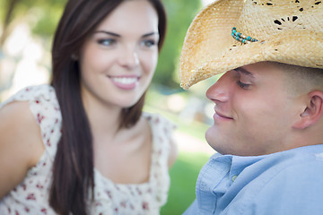 Image showing Mixed Race Romantic Couple with Cowboy Hat Flirting in Park