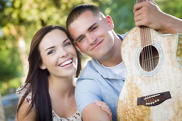 Image showing Mixed Race Couple Portrait with Guitar in Park