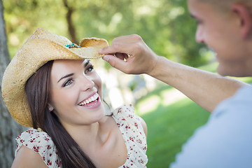 Image showing Mixed Race Romantic Couple with Cowboy Hat Flirting in Park