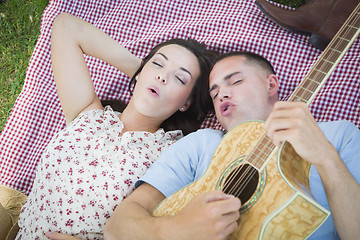 Image showing Mixed Race Couple at the Park Playing Guitar and Singing