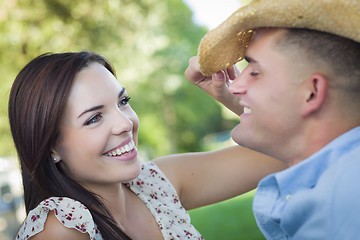 Image showing Mixed Race Romantic Couple with Cowboy Hat Flirting in Park