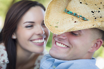 Image showing Mixed Race Romantic Couple with Cowboy Hat Flirting in Park