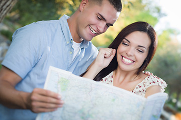 Image showing Mixed Race Couple Looking Over Map Outside Together