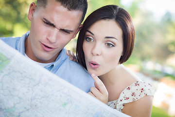 Image showing Mixed Race Couple Looking Over Map Outside Together