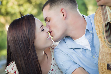 Image showing Mixed Race Couple Portrait with Guitar in Park