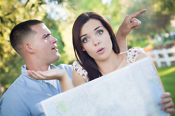 Image showing Lost and Confused Mixed Race Couple Looking Over Map Outside