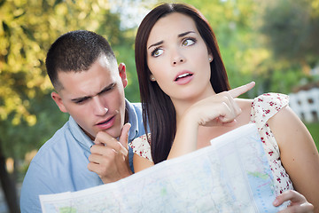 Image showing Lost and Confused Mixed Race Couple Looking Over Map Outside