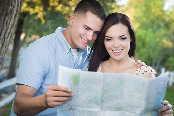 Image showing Mixed Race Couple Looking Over Map Outside Together