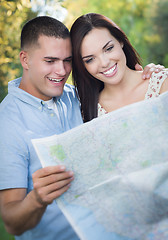 Image showing Mixed Race Couple Looking Over Map Outside Together