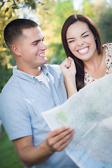 Image showing Mixed Race Couple Looking Over Map Outside Together