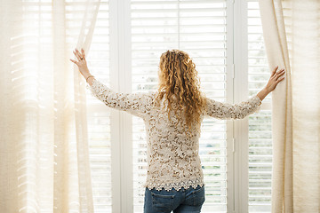 Image showing Woman looking out window