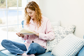 Image showing Woman reading book by window