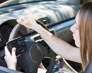 Image showing Teenage girl texting and driving