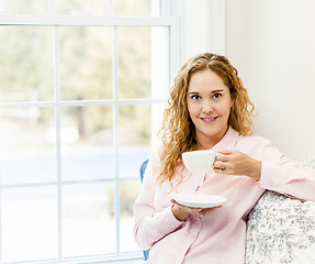 Image showing Woman relaxing by the window with beverage