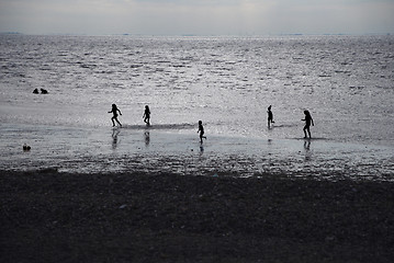 Image showing Children playing at the beach in silhouette