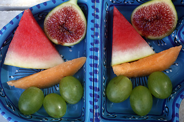 Image showing Grapes, figs, watermelon and melon in a blue bowl