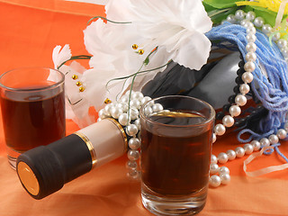 Image showing two glasses, bottle of wine and white flowers. festive arrangement with sparkling champagne and flowers