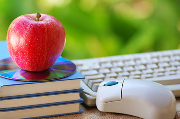 Image showing Red apple on book, DVD and mouse