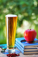 Image showing Cold beer and apple on books