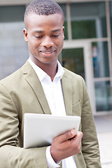 Image showing smiling successful businessman with tablet pc outdoor