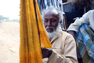Image showing Fisherman who weaves a fishing net before the next fishing in Kumrokhali, West Bengal, India.