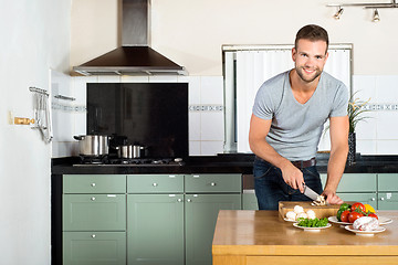 Image showing Man Cutting Vegetables At Kitchen Counter