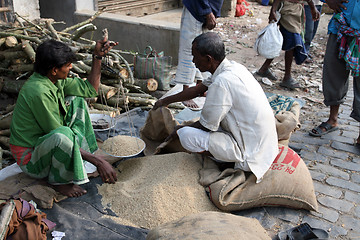 Image showing Man selling rice at a street stall outside the market in Kumrokhali, West Bengal, India