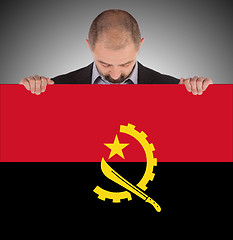 Image showing Businessman holding a big card, flag of Angola