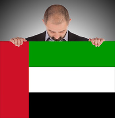Image showing Businessman holding a big card, flag of the United Arab Emirates