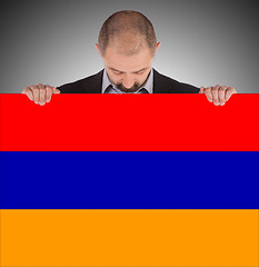Image showing Businessman holding a big card, flag of Armenia
