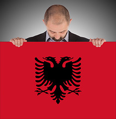 Image showing Businessman holding a big card, flag of Albania